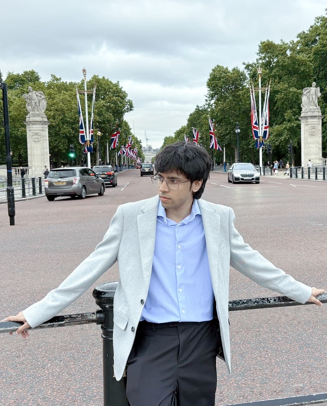Shangirne Kharbanda standing near Buckingham Palace in London, wearing a blazer and blue shirt.